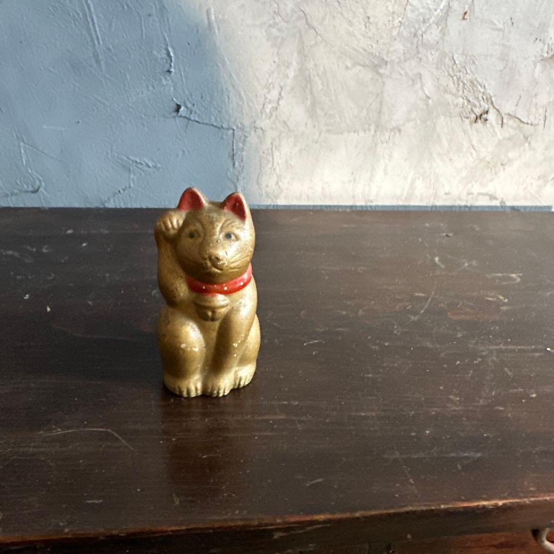シュールなお顔の陶器製　金色の招き猫貯金箱