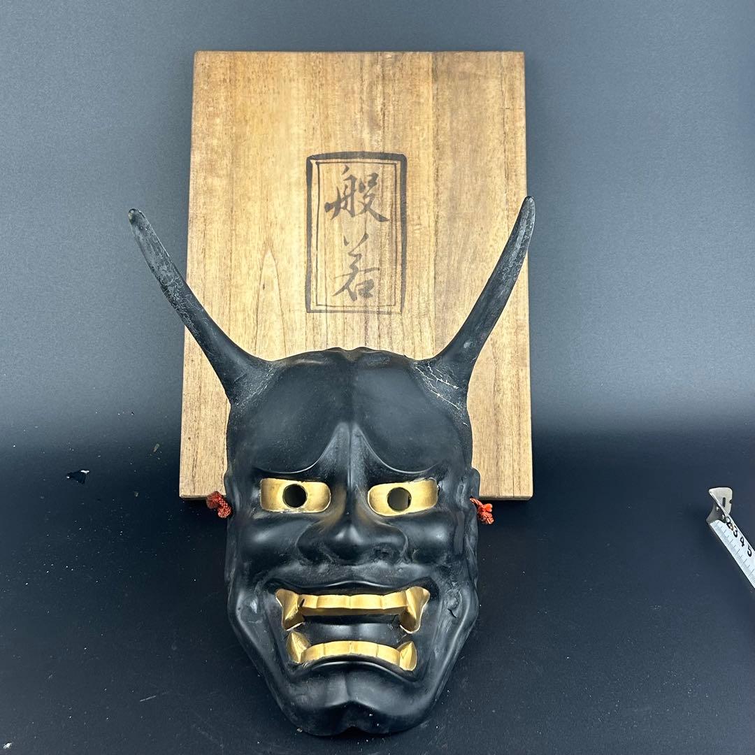 お面　黒と金の角のあるデザイン